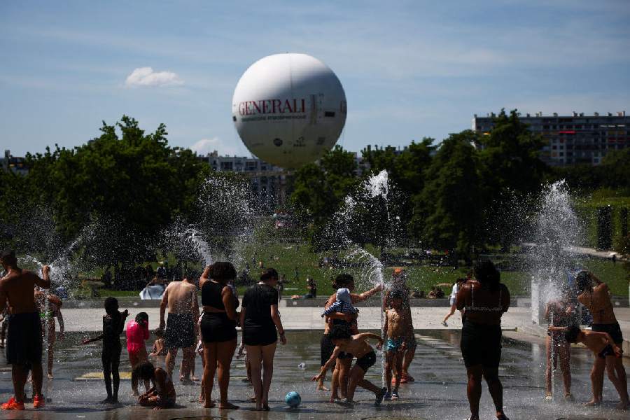 People play in a fountain at the Andre Citroen park as temperatures rise in Paris during a second heatwave affecting a large part of France, June 21, 2026.