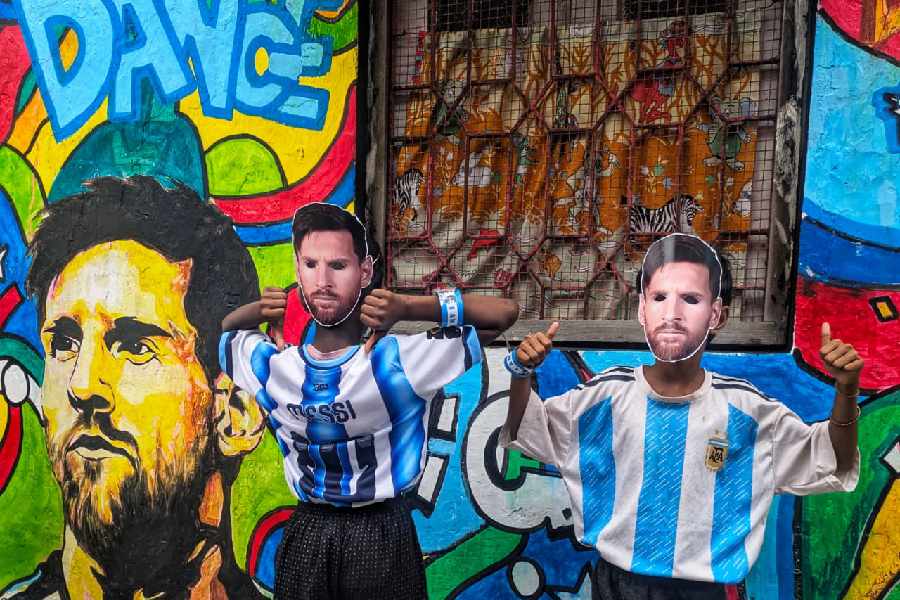 An Argentina fan struck a pose in front of a Messi graffiti in the Fifa Gali, Shyambazar