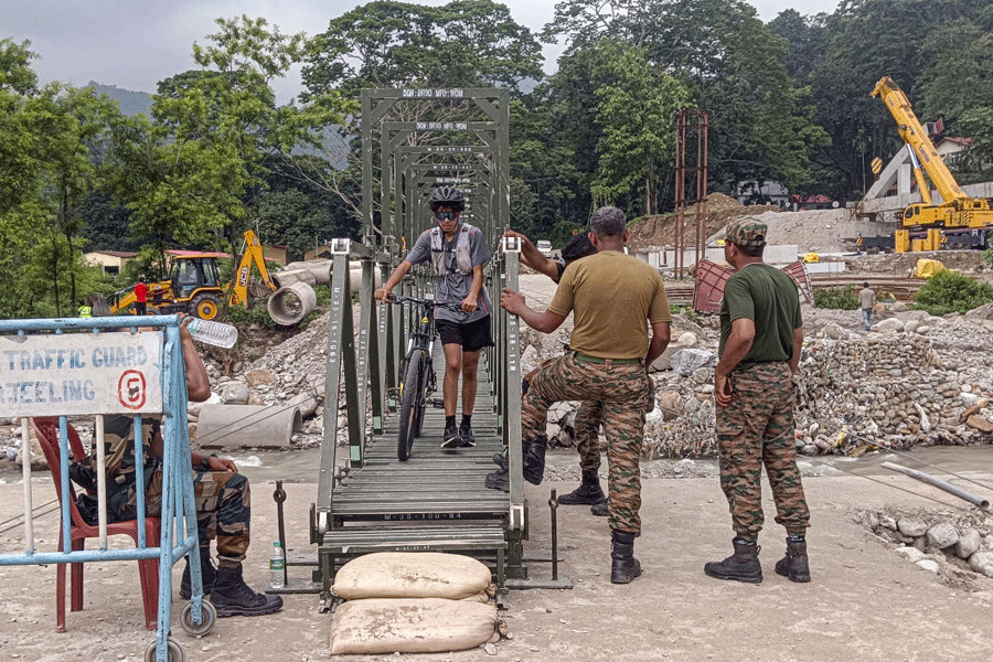 Indian Army personnel check commuters crossing a temporary Bailey bridge constructed at Dudhia to restore connectivity between Siliguri and Mirik, in Darjeeling district, Wednesday, June 24, 2026.