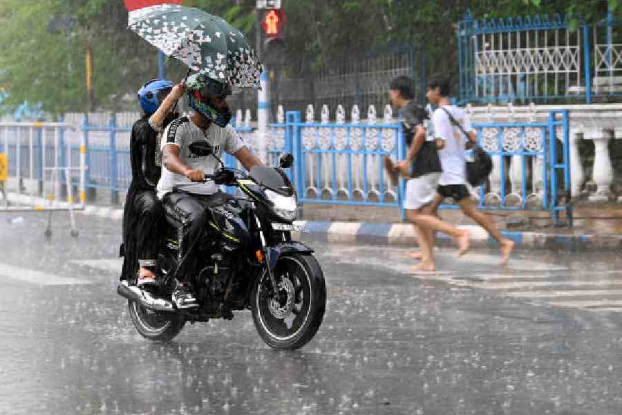 Commuters amid rain on JL Nehru Road on Sunday afternoon. Picture by Sanat Kr Sinha 