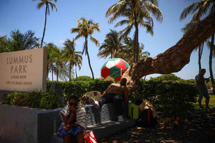 An inflatable soccer ball sits on Lummus Park as a man sleeps under a shaded tree amid a heat advisory in Miami Beach, Florida, U.S., June 17, 2026.