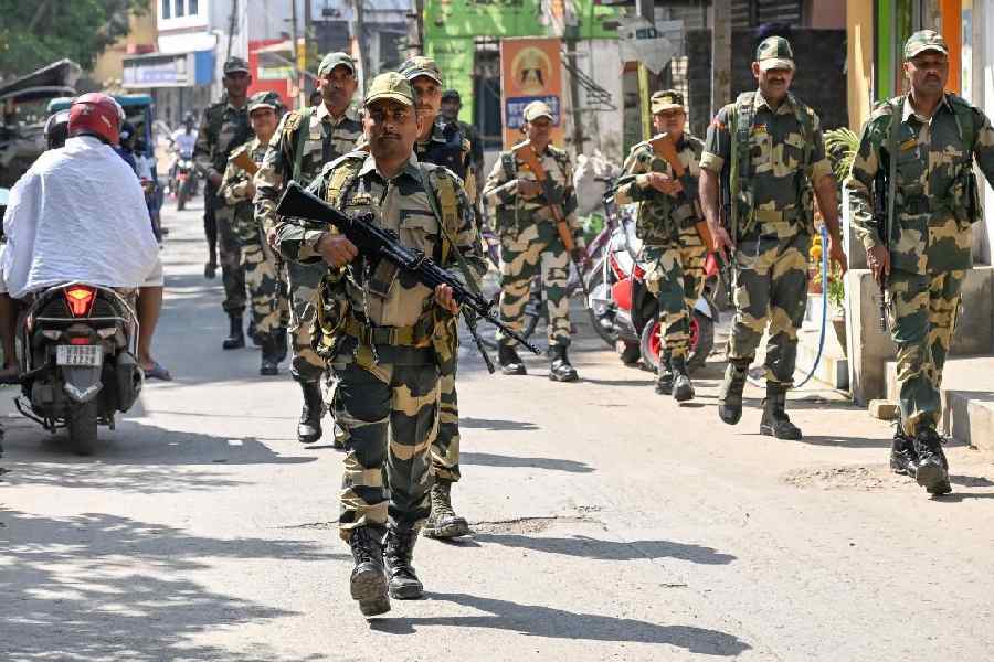Paramilitary personnel conduct a route march in Santipur, Nadia, on the day the post-SIR final voter list was published. 