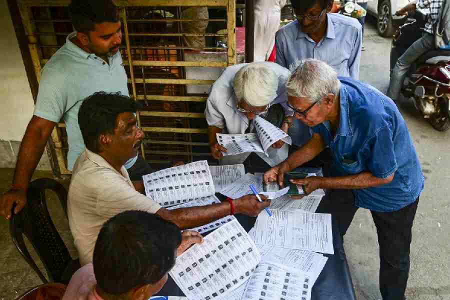 Voters check their names in the list after the Election Commission published West Bengal's post-SIR electoral rolls, in Kolkata, Saturday, Feb. 28, 2026.