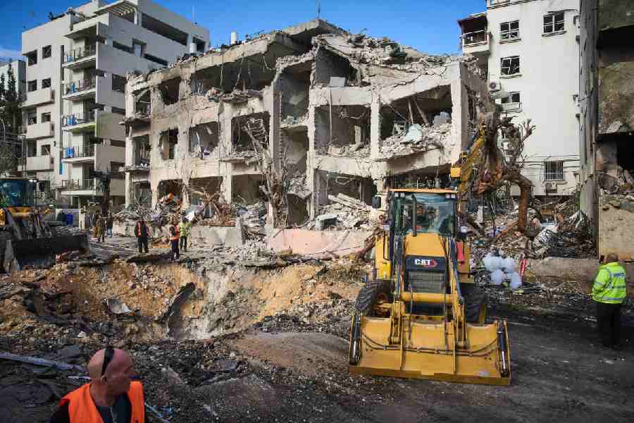 Rescue workers and military personnel survey the scene of a direct hit a day after an Iranian missile struck in Tel Aviv, Israel, Sunday, March 1, 2026.