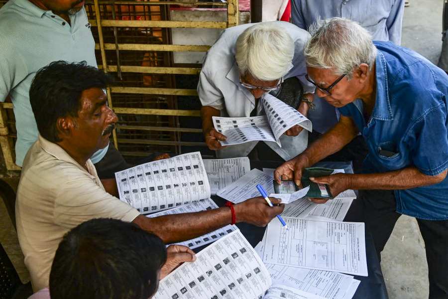 Voters check their names in the list after the Election Commission published West Bengal's post-SIR electoral rolls, in Kolkata, Saturday, Feb. 28, 2026.