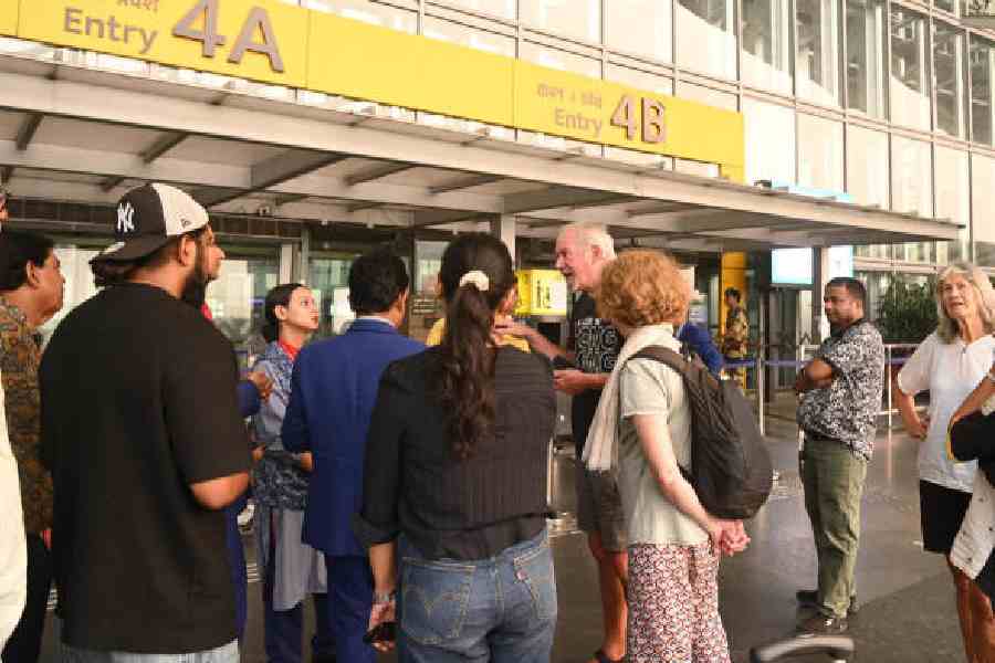 Passengers talk to airline officials at the international departure level of the Calcutta airport on Sunday