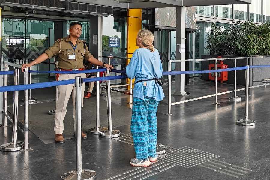 A passenger talks to a security personnel at the Kolkata Airport
