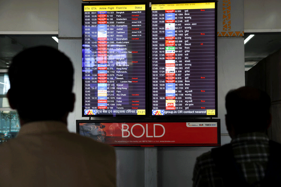 People look at a screen displaying flight information at the Indira Gandhi International airport, amid the U.S.-Israel conflict with Iran, in New Delhi, India, March 3, 2026.