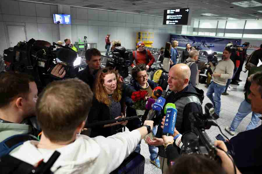 An unidentified passenger is welcomed by his partner with roses as he speaks to the media following the evacuation from Dubai amid the U.S.-Israeli conflict with Iran at the airport in Frankfurt, Germany, March 3, 2026.
