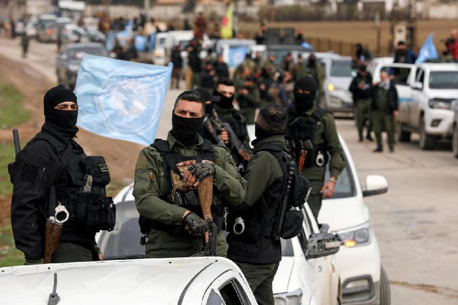 Kurdish internal security forces stand at the back of a pick-up truck, February 13, 2026