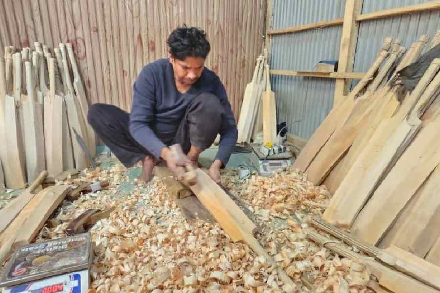 A worker chisels a cricket bat at a manufacturing unit in Kashmir.