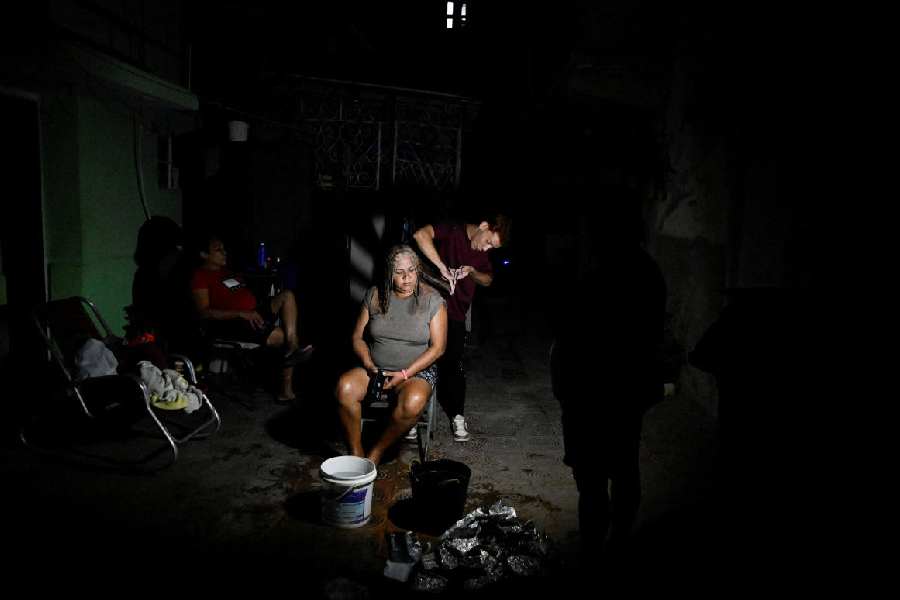 Yuleisis Mendez has her hair cut on the street during a mass blackout across most of the country, in Havana, Cuba March 4, 2026