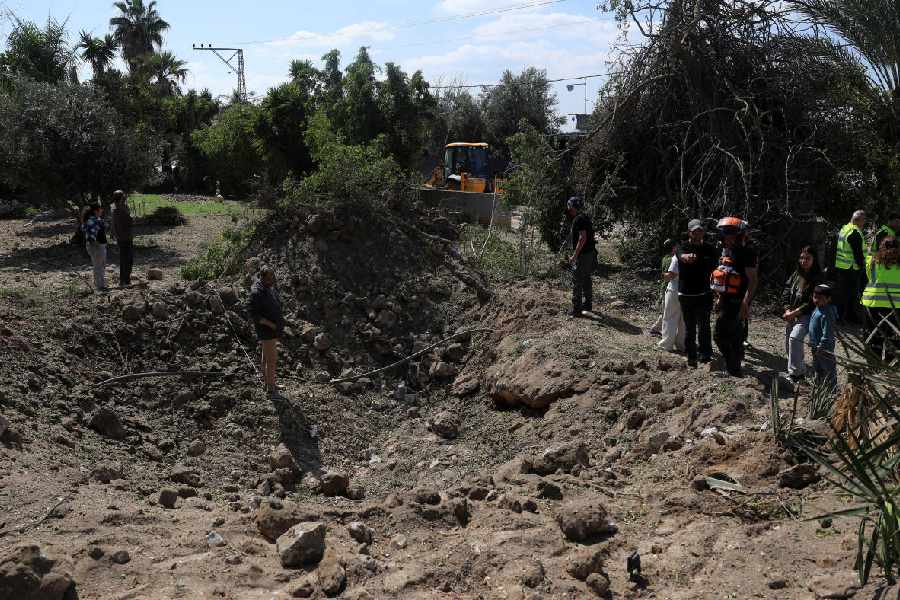 People in central Israel look at the damage caused by missiles launched from Iran