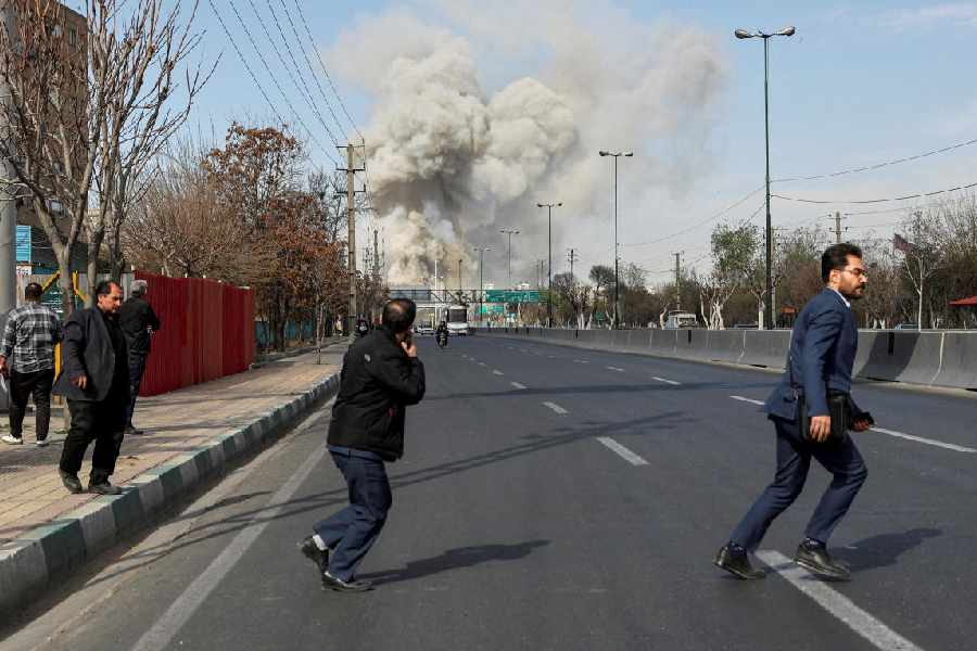 People run as smoke rises following an explosion, amid the U.S.-Israeli conflict with Iran, in Tehran, Iran, March 5, 2026.