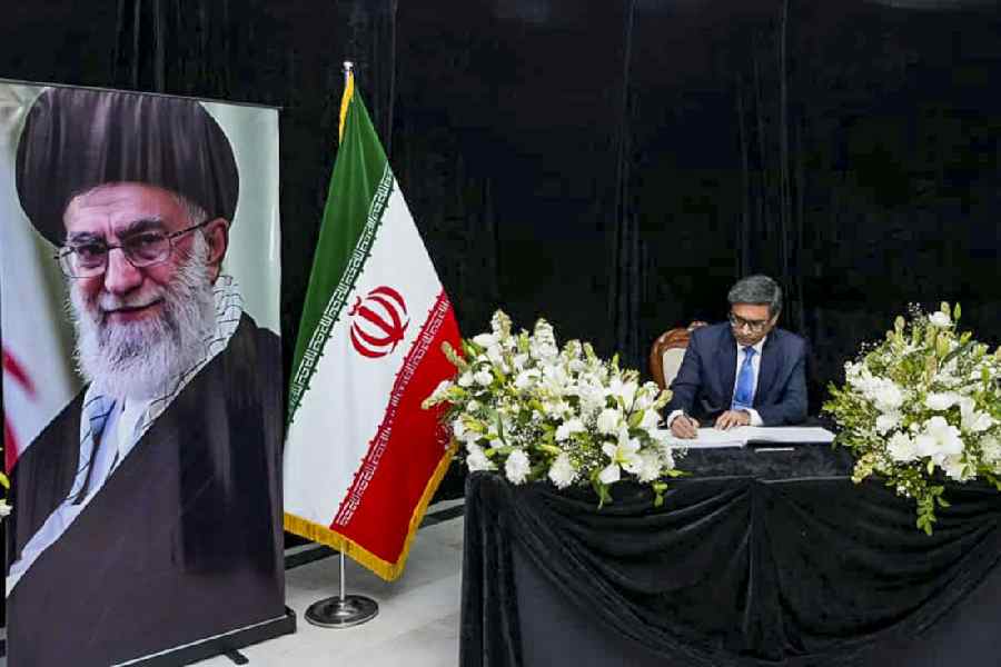 Vikram Misri on Thursday signs the condolence book at the Iran embassy in New Delhi, sitting beside a picture of Ayatollah Ali Khamenei.