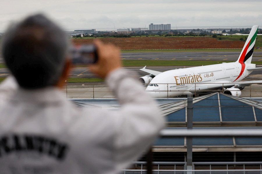 A person takes a photo of an Emirates flight arriving from Dubai as it lands at Taoyuan International Airport, amid the U.S.-Israel conflict with Iran, in Taoyuan, Taiwan, March 5, 2026.