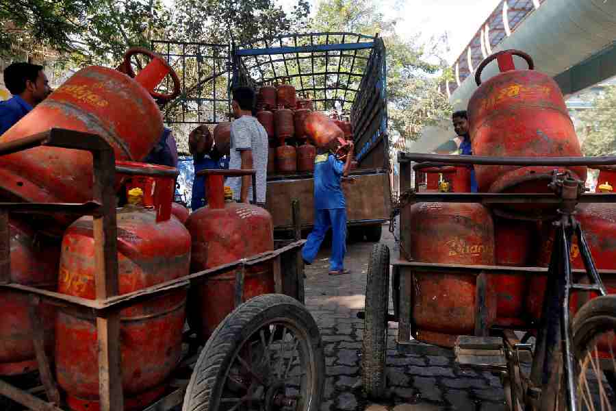 Workers load liquefied petroleum gas (LPG) cooking cylinders onto a supply truck outside a distribution centre in Mumbai, India, February 19, 2015.