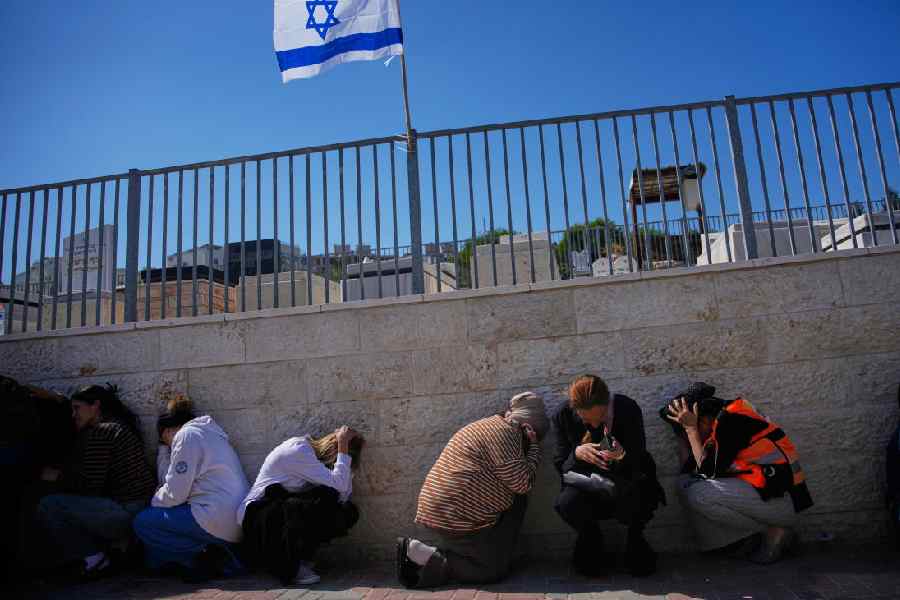 Mourners in Beit Shemesh, Israel, take cover while air-raid sirens warn of incoming missiles launched by Iran toward Israel