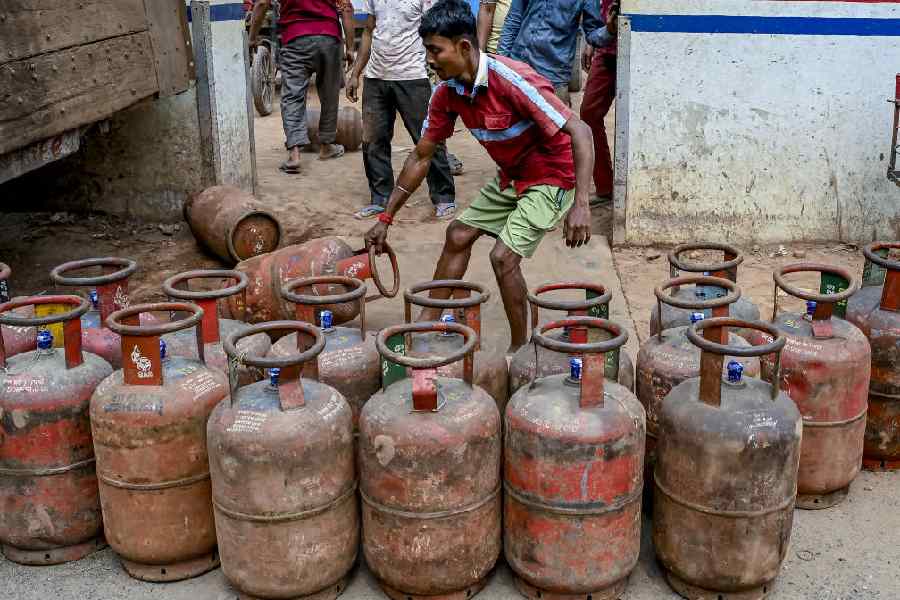 A worker carries LPG cylinders in Nadia on Saturday.