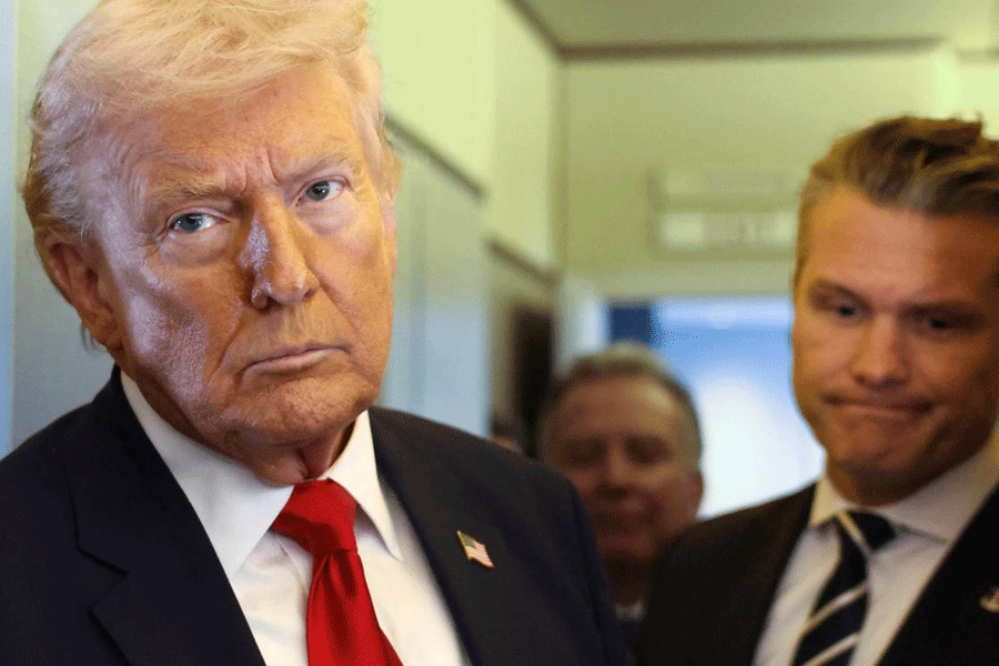 U.S. President Donald Trump, with Secretary of Defense Pete Hegseth at his side, looks on as he speaks to reporters aboard Air Force One on a flight from Dover, Delaware, to Miami, Florida, U.S., March 7, 2026.
