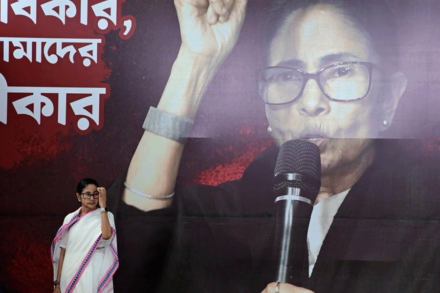 West Bengal Chief Minister Mamata Banerjee, centre, during a sit-in for the third consecutive day, in Kolkata, Sunday, March 8, 2026. Banerjee staged the sit-in to protest against the LPG price hike on the occasion of International Women's Day.