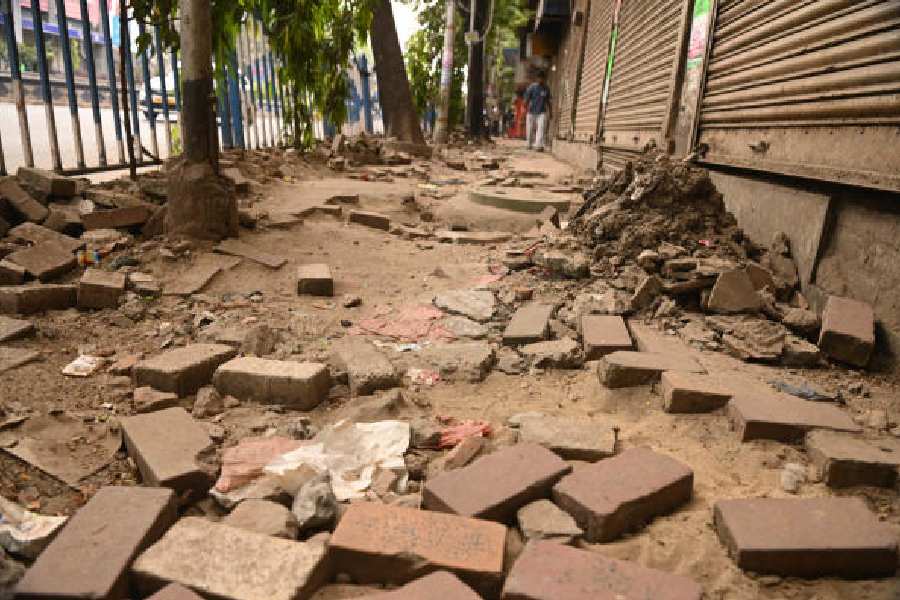 A dug-up pavement near Park Street and (right) damaged paver blocks of a footpath along CR Avenue near Girish Park Metro station 