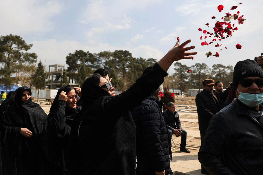 A mourner throws flowers during a funeral ceremony for victims of Israeli and U.S. strikes, amid the U.S.-Israeli conflict with Iran, in Tehran, Iran, March 9, 2026.
