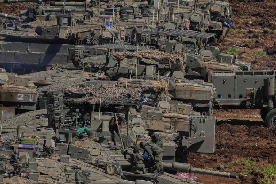 Israeli soldiers work on tanks at a staging area in northern Israel near the border with Lebanon, Israel, Sunday, March 8, 2026
