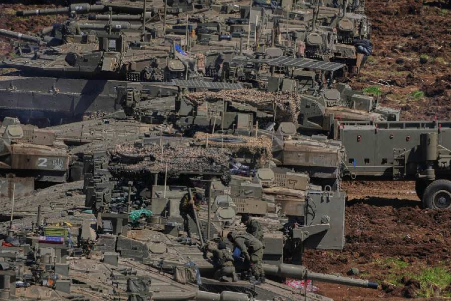 Israeli soldiers work on tanks at a staging area in northern Israel near the border with Lebanon, Israel, Sunday, March 8, 2026