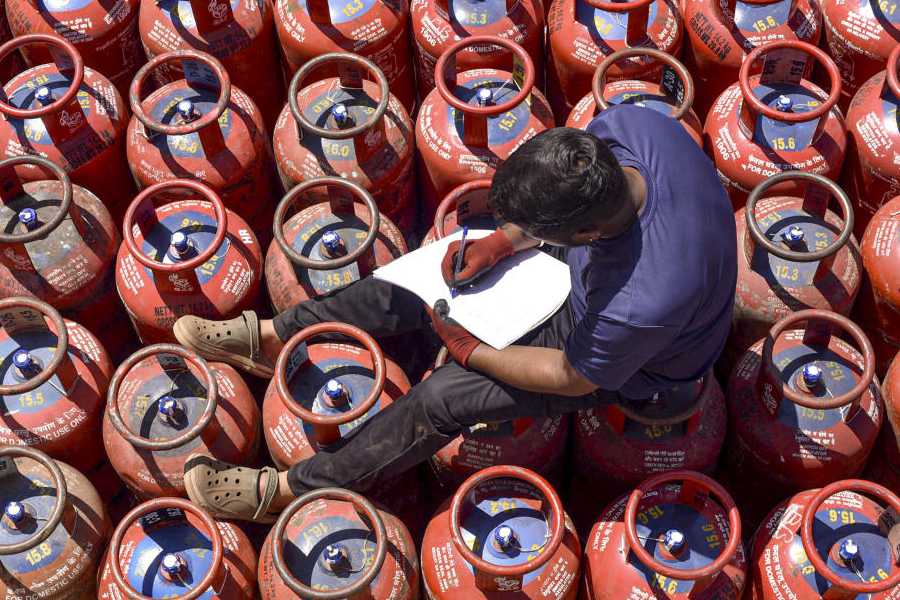 A worker sits over LPG cylinders during distribution at a gas agency, in Chikkamagaluru, Karnataka, Wednesday, March 11, 2026. Long queues were seen at several gas agencies amid an ongoing LPG supply shortage in the country.