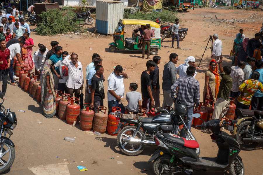 People stand in a queue with their empty LPG cylinders outside a gas agency amid supply disruptions following the U.S.-Israeli conflict with Iran, in Ahmedabad, India, March 12, 2026.