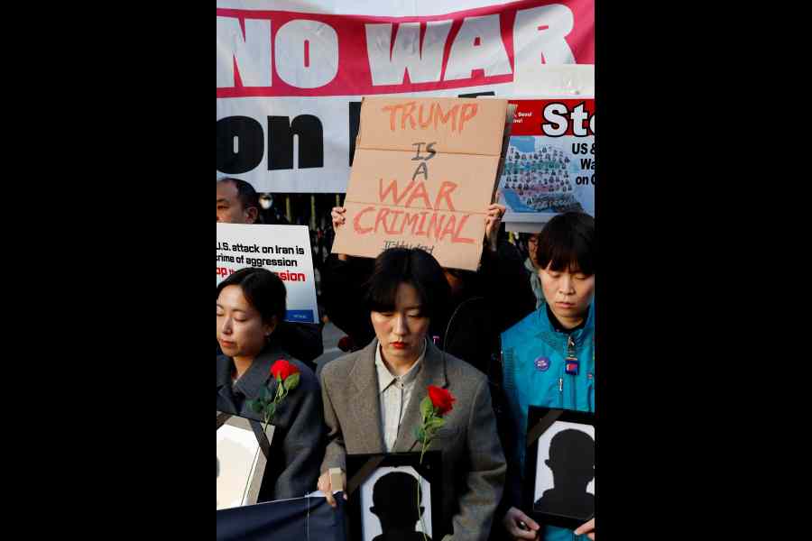 Participants hold mock funeral portraits during a protest to condemn the U.S. and Israeli attacks on Iran and commemorate students killed in a strike on a girls' primary school in Minab in southern Iran on February 28, in front of the Israeli embassy in Seoul, South Korea, March 12, 2026.