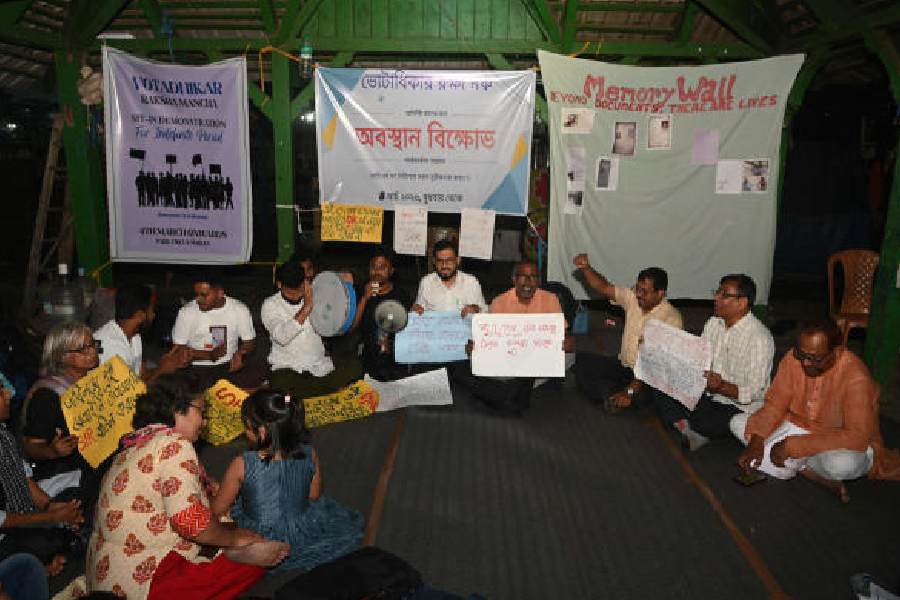 Protesters at Park Circus Maidan, with the memory wall that was set up on Wednesday at the back