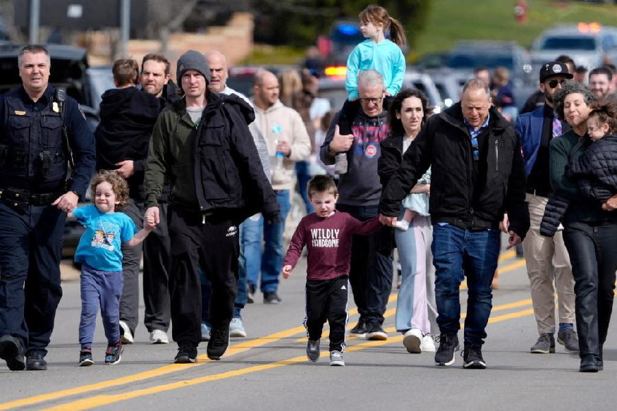 Parents are escorted by police down Walnut Lake Road back to their cars after being reunited with their children after a suspect crashed his truck into the hallway of Temple Israel synagogue in West Bloomfield, Michigan, U.S., March 12, 2026.