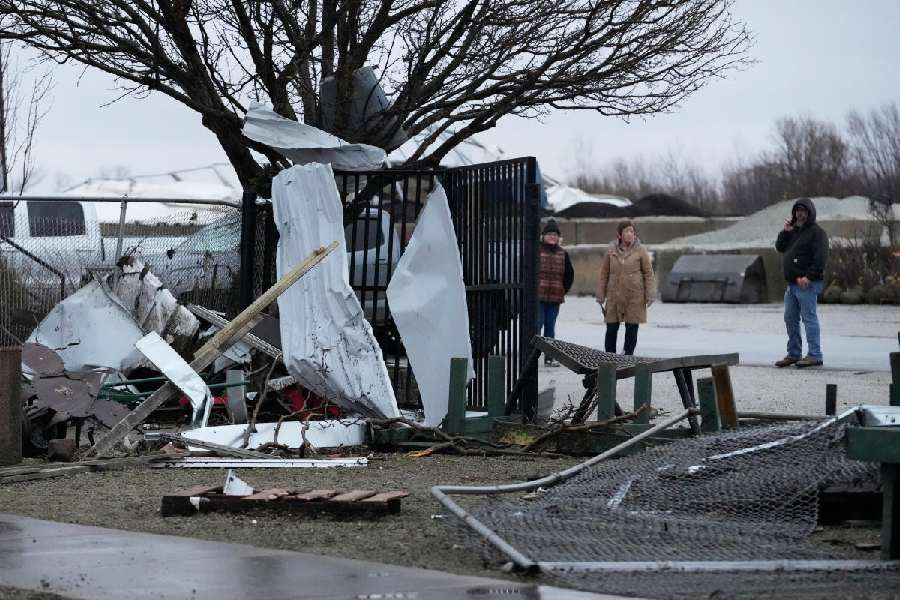 People look over the damage in the aftermath of a powerful storm that ripped through the area a day earlier in Kankakee, Ill., Wednesday, March 11, 2026.