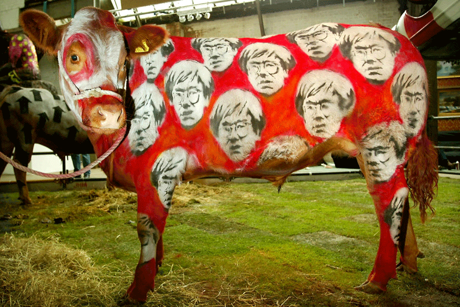 A cow painted red and decorated with pictures of the late U.S. artist Andy Warhol stands in the Turf..