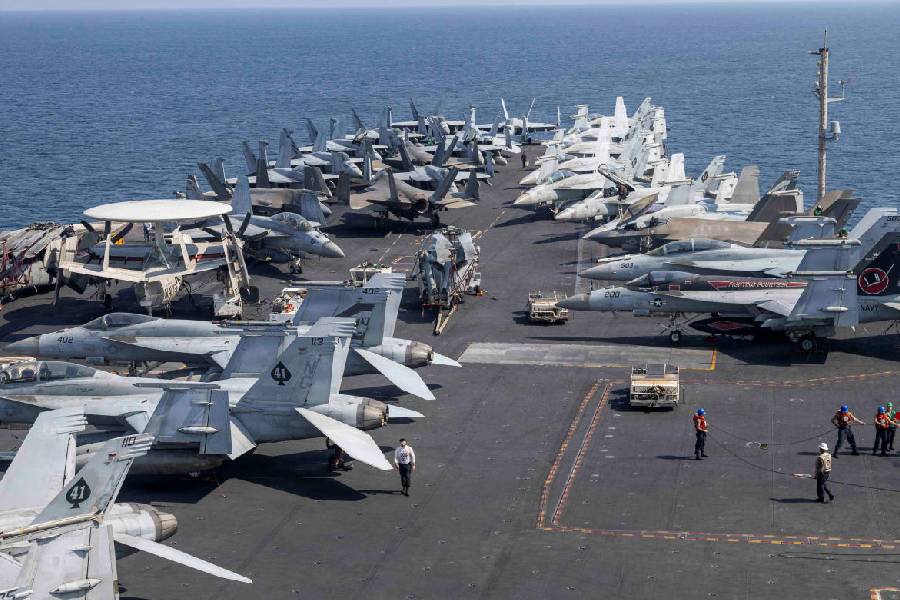 Dozens of U.S. Navy and Marine Corps fighter jets and aircraft parked in tight rows across the flight deck of the USS Abraham Lincoln at sea.