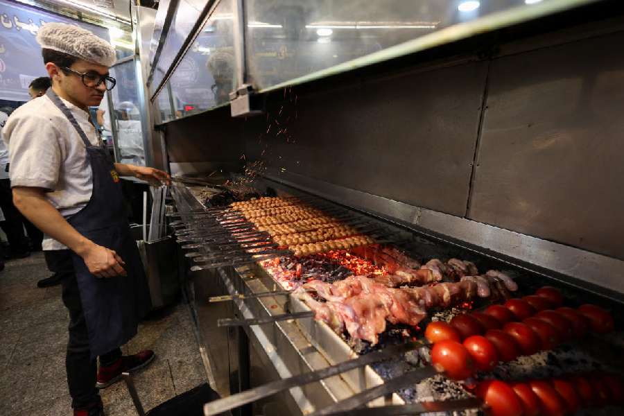 A man prepares food at a restaurant amid heightened tensions linked to the US-Israeli conflict with Iran, in Tehran, Iran, March 14, 2026.