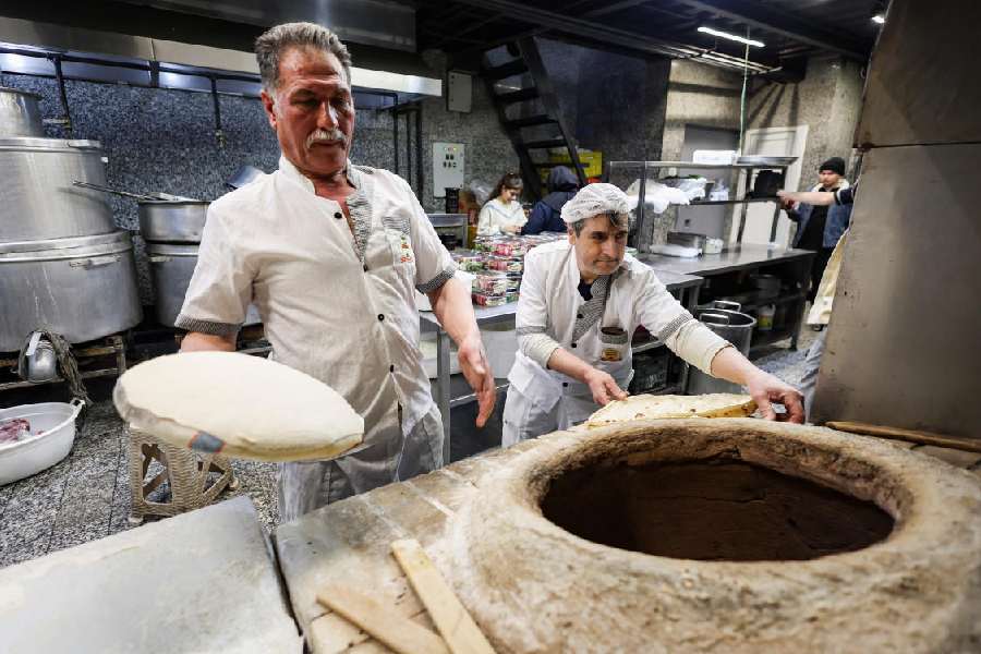 Men prepare bread at a restaurant, amid heightened tensions linked to the US-Israeli conflict with Iran, in Tehran, Iran, March 13, 2026.