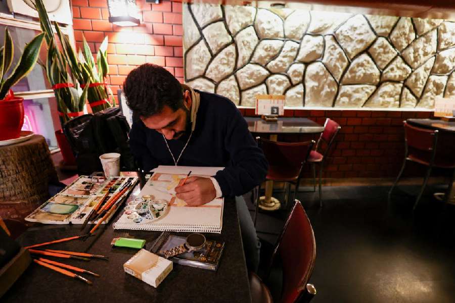 An artist draws at a cafe, amid heightened tensions linked to the US-Israeli conflict with Iran, in Tehran, Iran, March 13, 2026.