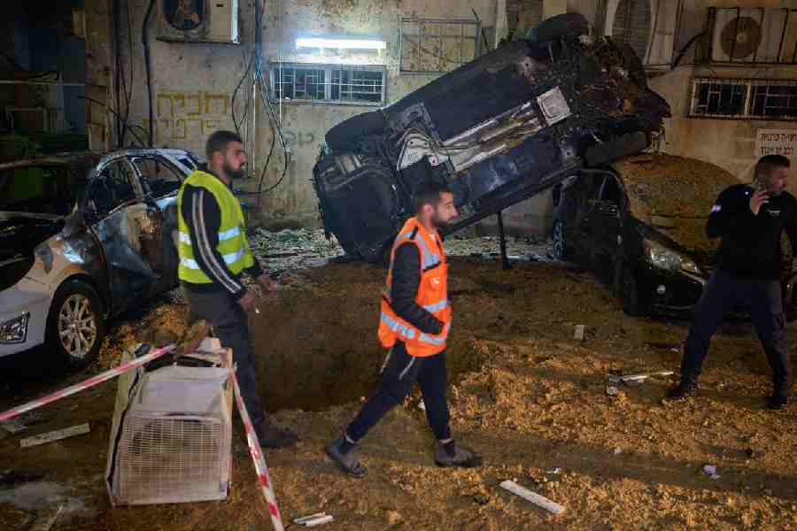 Israeli security forces inspect damage at the site of an Iranian missile strike in Holon, central Israel, Sunday, March 15, 2026.