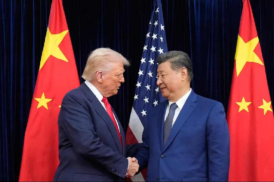 Donald Trump, left, and Chinese President Xi Jinping, right, shake hands before their meeting at Gimhae International Airport in Busan, South Korea