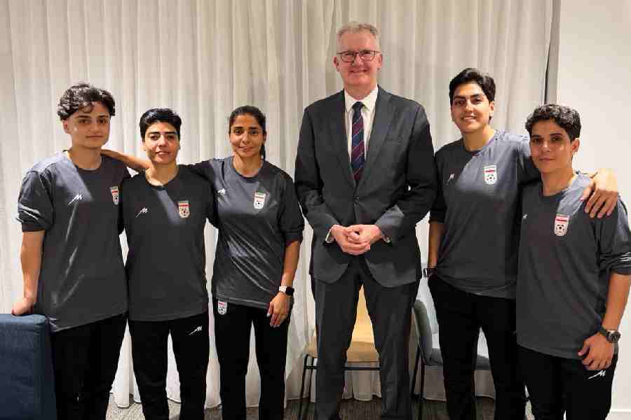 Australia's Minister for Home Affairs Tony Burke's office, the Minister Tony Burke, center, poses in an undisclosed location with five Iranian women soccer players who have been granted asylum in Australia, Tuesday, March 10, 2026