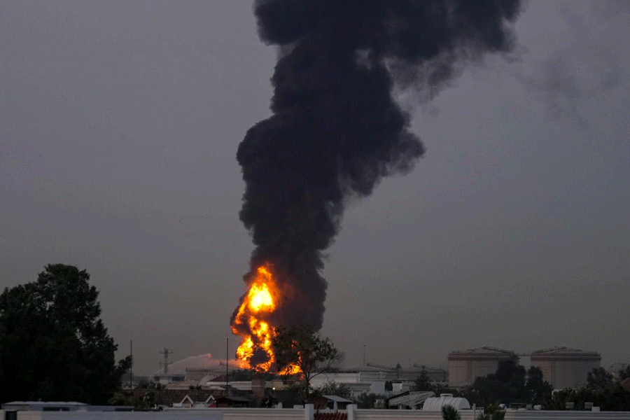 Fire and plumes of smoke rises after a drone struck a fuel tank forcing the temporary suspension of flights. near Dubai International Airport, in United Arab Emirates, early Monday, March 16, 2026.