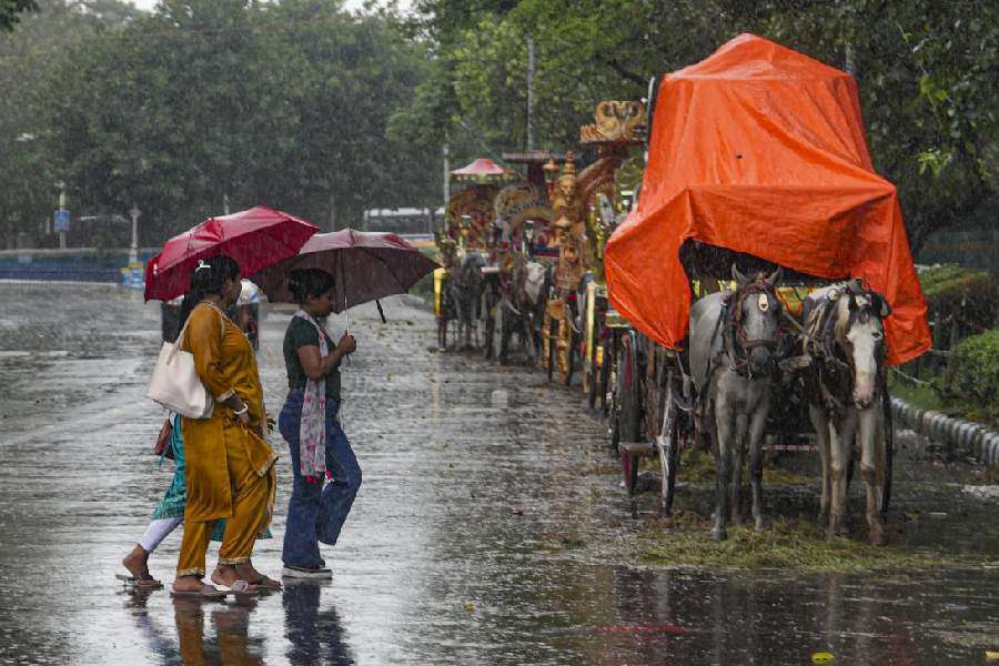 People commute during rainfall in Kolkata.