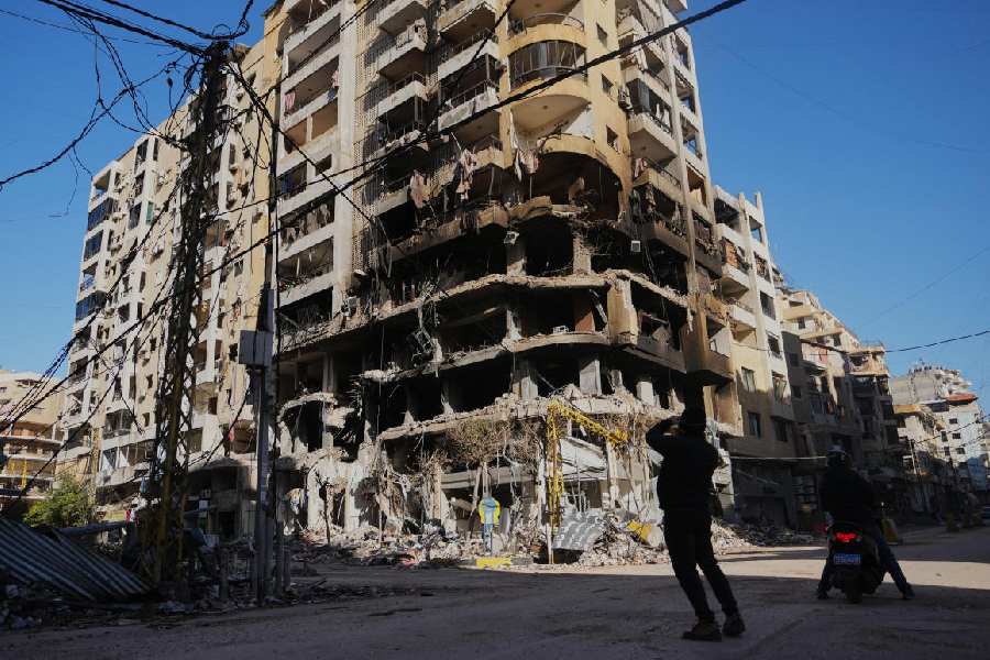 man photographs a building damaged by an Israeli airstrike in Dahiyeh, Beirut's southern suburbs, Lebanon