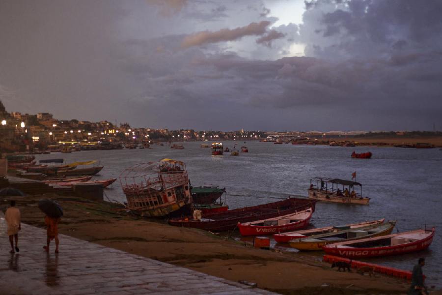 Boats stand anchored as it rains, at a ghat on the banks of the Ganga river, in Varanasi,