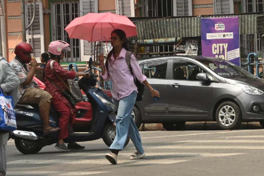 A pedestrian uses an umbrella near Elgin Road on a hot Tuesday afternoon.