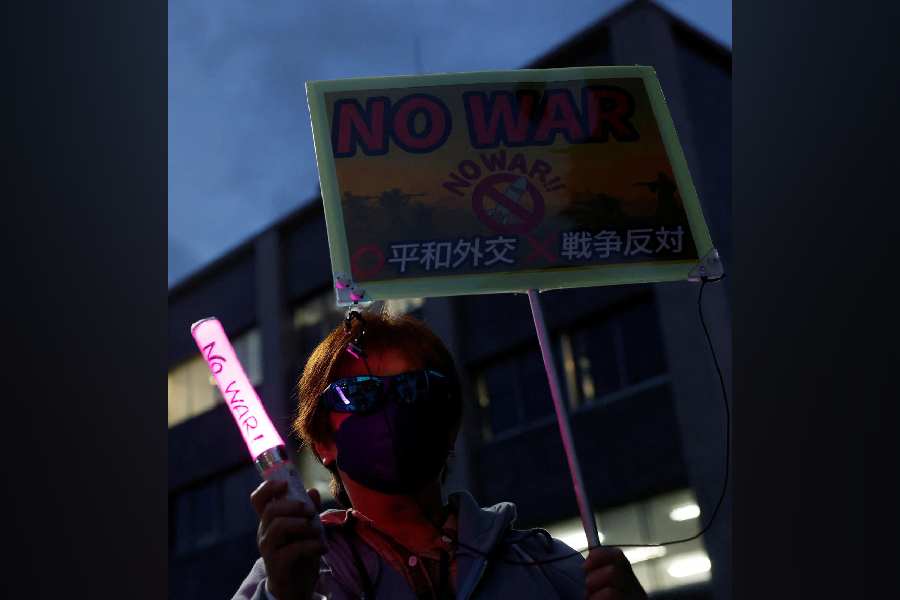 A woman holds a sign at an anti-war rally ahead of Japanese Prime Minister Sanae Takaichi's visit to meet with US President Trump, Tokyo, Japan, March 18, 2026.