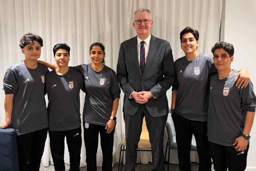 Minister for Home Affairs, Tony Burke, poses with five Iranian women footballers who were  granted asylum in Australia, March 10, 2026